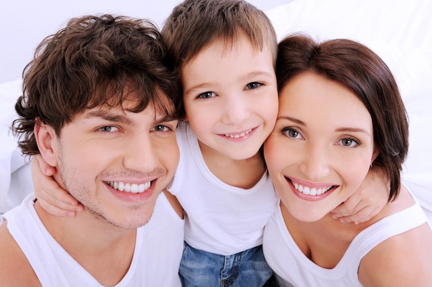 Foto gratuita bellos rostros sonrientes de personas. una familia joven feliz de tres personas.