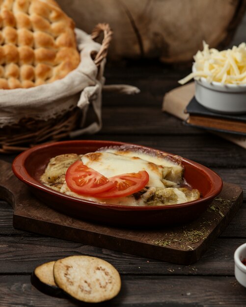 berenjena a la parrilla cubierta con queso derretido en una sartén de cerámica