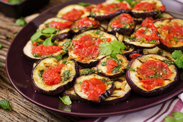 Berenjenas a la parrilla con salsa de tomate, ajo, cilantro y menta. Comida vegana. Berenjena a la plancha.