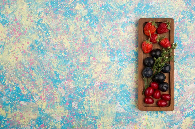 Berry Mix en un plato de madera aislado sobre fondo azul.