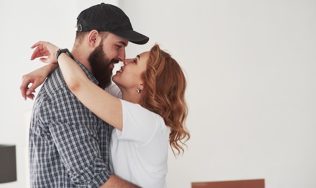 Besándose. Pareja feliz juntos en su nueva casa. Concepción de mudanza