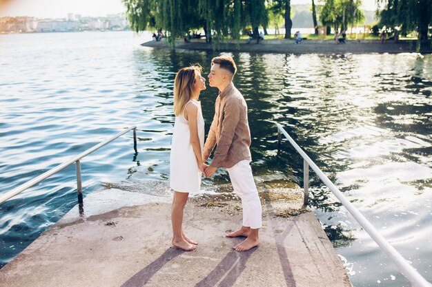 Besar pareja de pie en el muelle