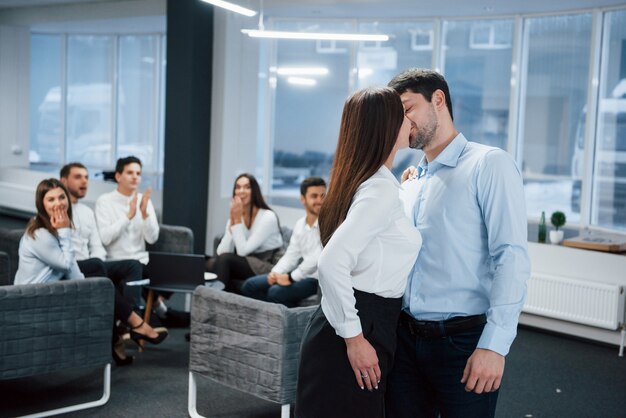 Un beso espontáneo y encantador entre dos empleados sorprendió a otros empleados de oficina