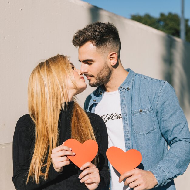 Besos gentil pareja con corazones de papel