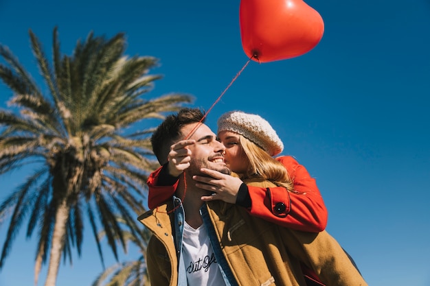 Besos hermosa pareja con globo rojo