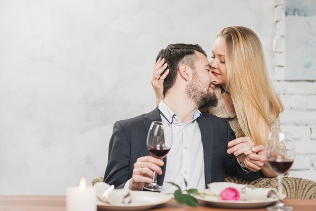 Besos pareja cercana con vino