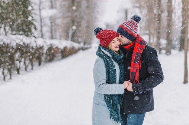 Besos tierna pareja en invierno