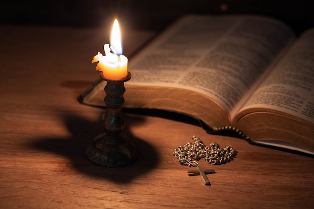 Biblia, cruz de madera y velas