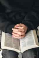 Foto gratuita biblia de libro abierto en primer plano de manos masculinas