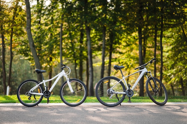 Bicicleta blanca de pie en el parque. Fitness matutino, soledad.