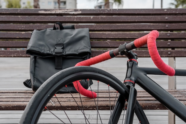 Bicicleta y bolso de hombre en un banco