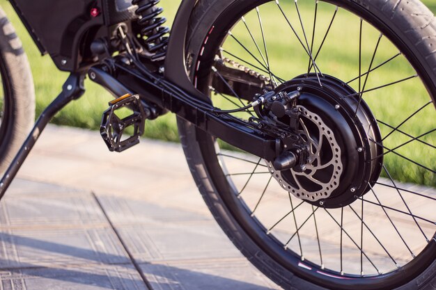Bicicleta de motor de bicicleta eléctrica de cerca con pedal y amortiguador trasero.