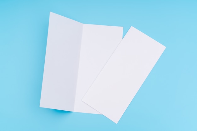 Bifold plantilla de papel blanco sobre fondo azul.