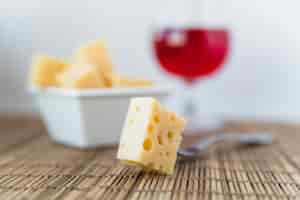 Foto gratuita bifurcación cerca de un juego de queso fresco en platillo y copa de vino en la mesa