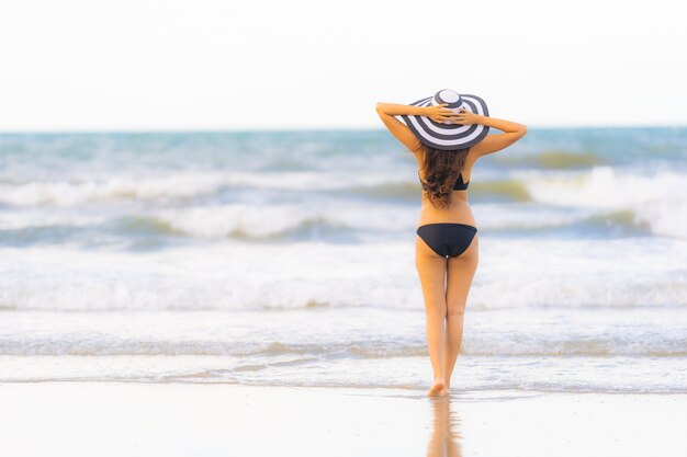 Bikini asiático joven hermoso del desgaste de mujer del retrato en el océano del mar de la playa