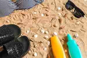 Foto gratuita bikini de verano y accesorios con estilo conjunto de playa, traje de verano de bikini de playa y arena de mar como fondo, vista superior, concepto