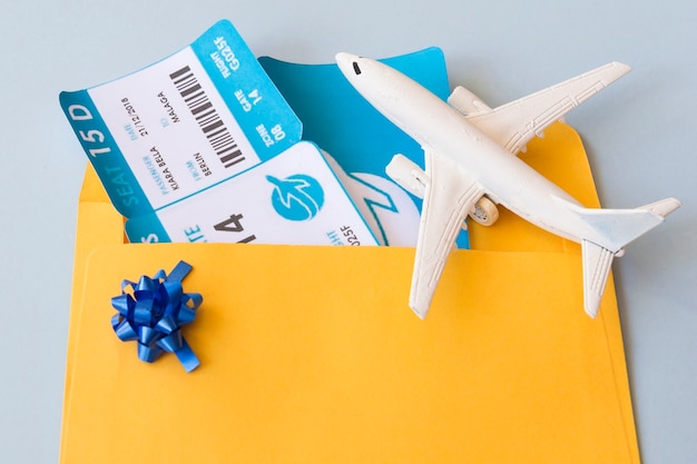 Billetes de avión en el caso del documento cerca de aviones de juguete