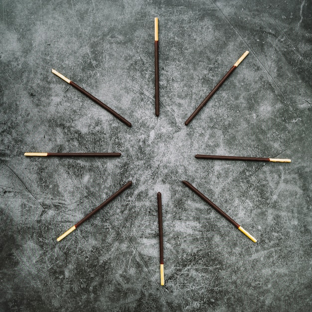 Biscuit stick deep in chocolate arreglado en circular sobre fondo de hormigón teñido