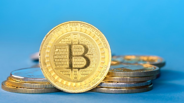 Bitcoin físico monedas de oro fondo azul.