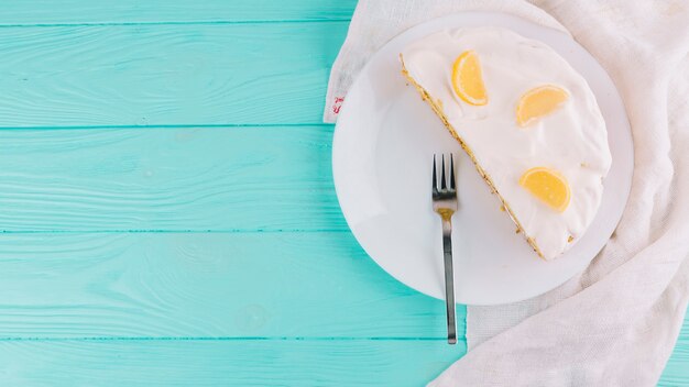 Bizcocho de limón cocido a la mitad con queso y rodajas de cítricos en un plato