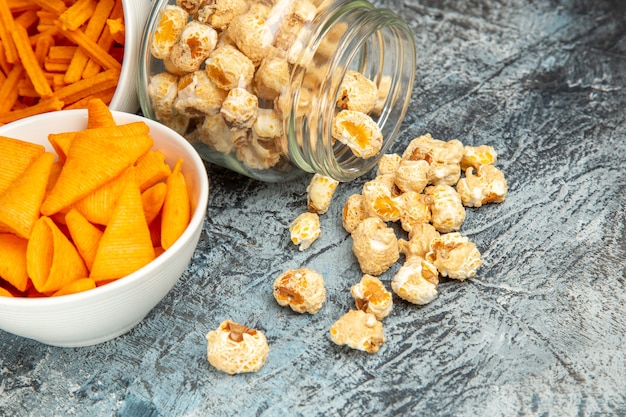 Bizcochos de queso de vista frontal con cips y palomitas de maíz sobre fondo claro