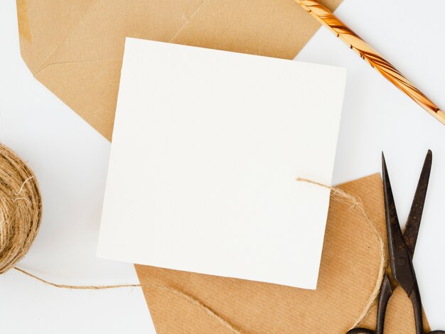 Blanco en blanco sobre sobres marrones con un lápiz de madera sobre un fondo blanco.