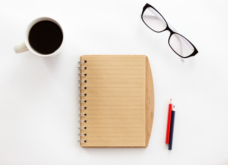 Foto gratuito blanco escritorio de oficina con un cuaderno y lápices, vasos