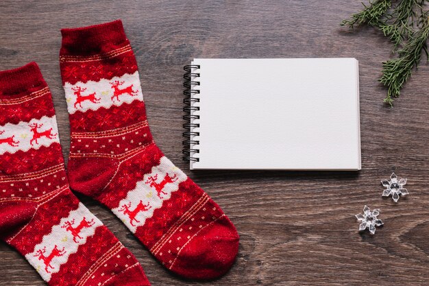 Bloc de notas en blanco con calcetines de Navidad en la mesa