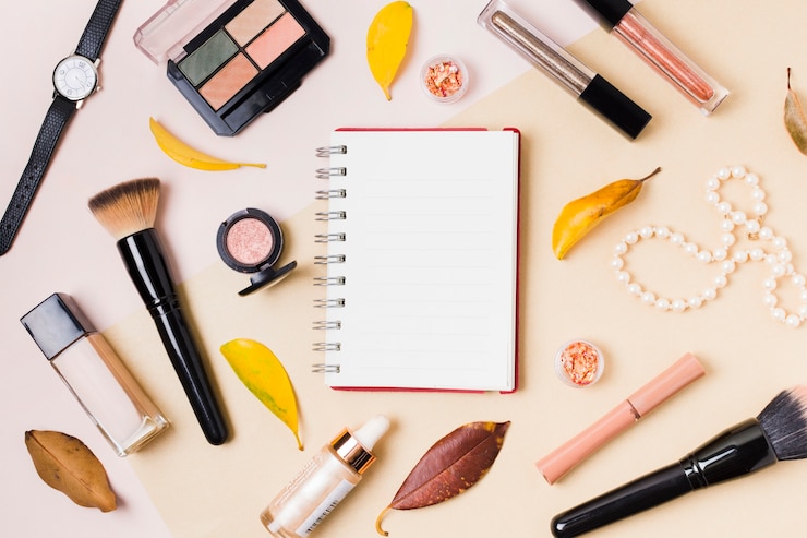 Foto gratuito bloc de notas con cosméticos de maquillaje en mesa de luz