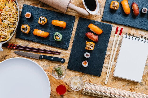 Bloc de notas y palillos cerca de sushi