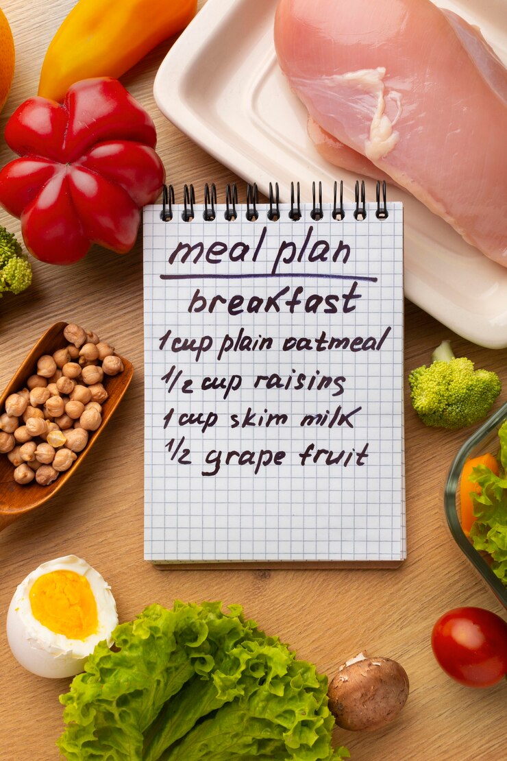 Foto gratuito bloc de notas de planificación de comidas y arreglo de alimentos