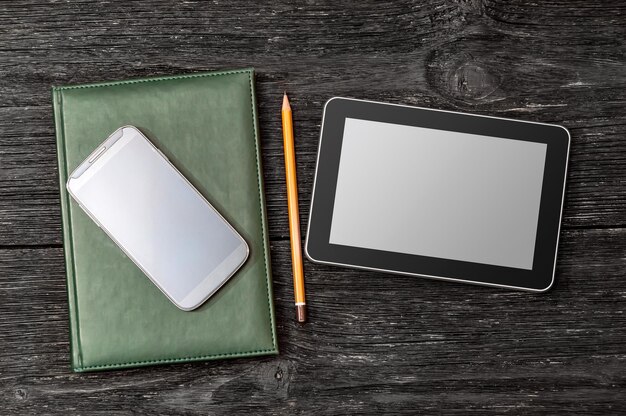 Bloc de notas, tablet pc y teléfono inteligente en la mesa de la oficina. concepto de educación y negocios. vista superior.