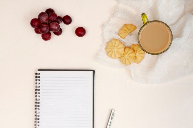 Bloc de notas vacío con galletas y uvas