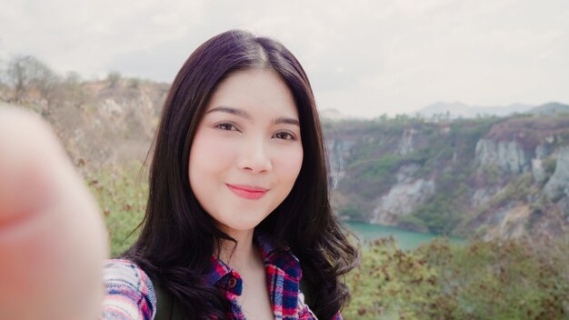 Blogger asiático mochilero mujer grabar video vlog en la cima de la montaña