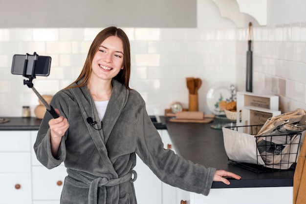 Blogger en bata y grabándose en la cocina