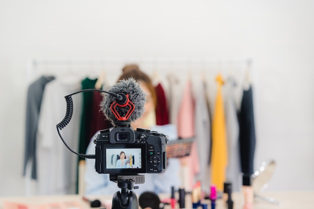 La blogger de belleza presenta cosméticos de belleza en la cámara frontal para grabar video