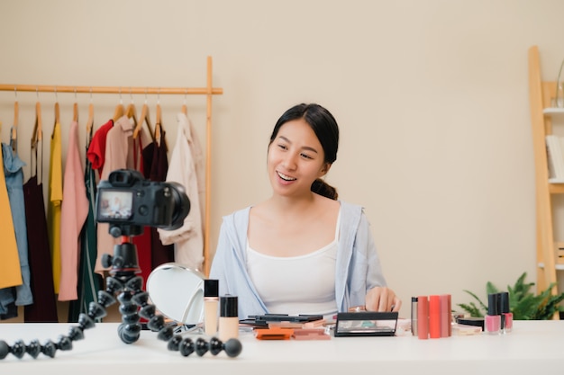 La blogger de belleza presenta cosméticos de belleza que se sientan en la cámara frontal para grabar video.