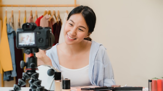 La blogger de belleza presenta cosméticos de belleza que se sientan en la cámara frontal para grabar video.