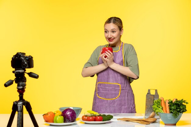 Blogger de comida adorable chef saludable grabando video para redes sociales con pimiento rojo