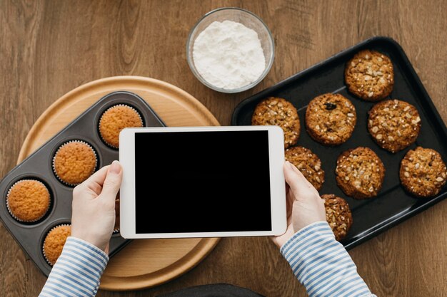 Blogger de comida femenina streaming en casa mientras cocina con tableta