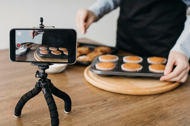 Foto gratuita blogger de comida femenina streaming con smartphone en casa mientras cocina