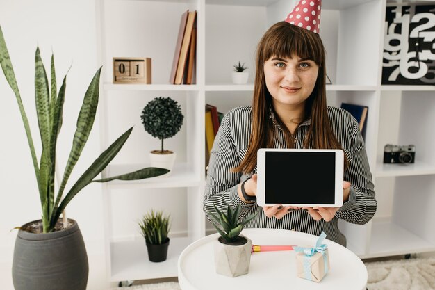 Blogger femenina streaming cumpleaños con tableta en casa