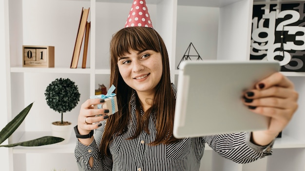 Blogger femenina streaming cumpleaños con tableta