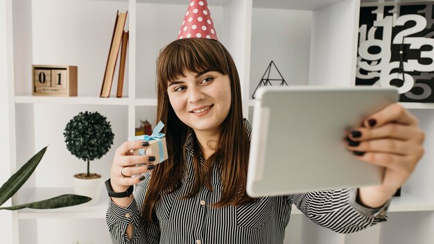 Blogger femenina streaming cumpleaños con tableta