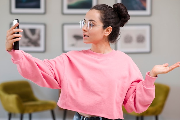 Blogger con gafas grabándose con el teléfono