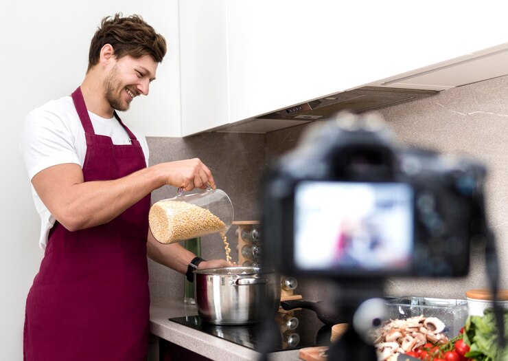 Foto gratuito blogger se graba mientras cocina en casa