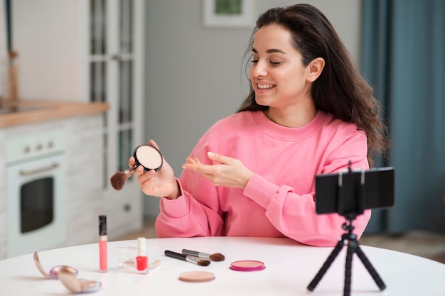 Blogger grabando video con accesorios de maquillaje