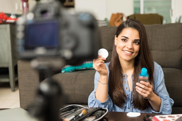 Blogger joven y apuesto que comparte consejos de belleza sobre la eliminación de maquillaje en un video