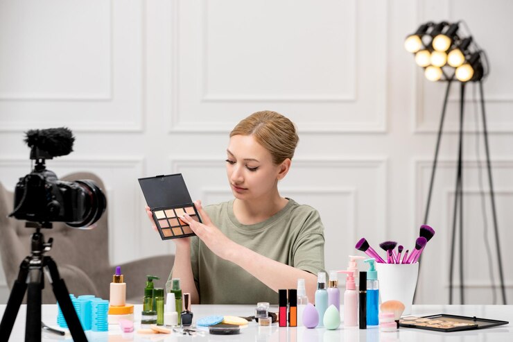 Foto gratuito blogger de maquillaje creando tutorial de maquillaje en la cámara joven linda linda chica poniéndose sombras de ojos