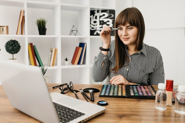 Foto gratuita blogger de maquillaje femenino con streaming en casa